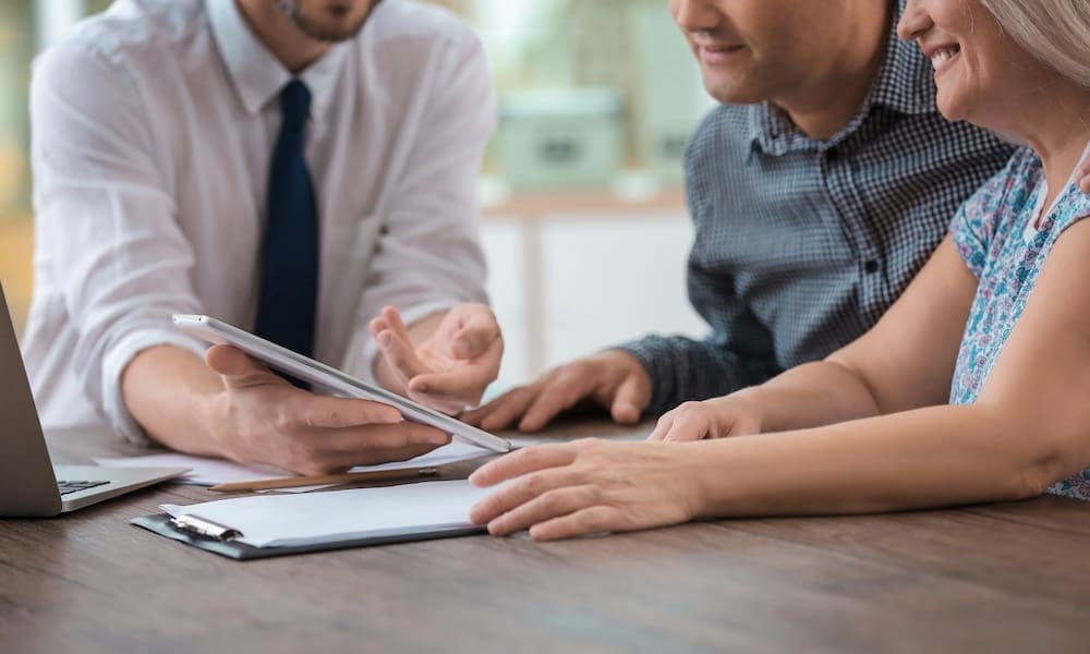 Male insurance agent consulting clients in office